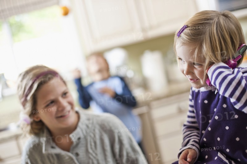 USA, Utah, Two girls (2-3, 10-11) in kitchen. Photo : Tim Pannell