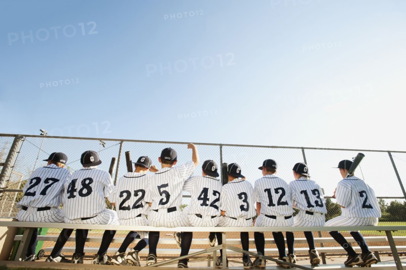 USA, California, Ladera Ranch, Boys (10-11) from little league sitting on bench, rear view.