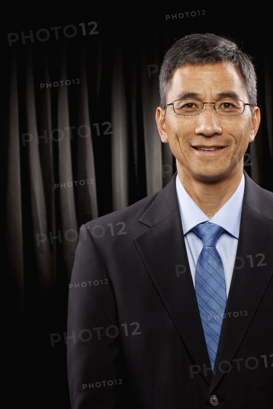 USA, Utah, Provo, Portrait of businessman standing in front of black curtain. Photo : FBP
