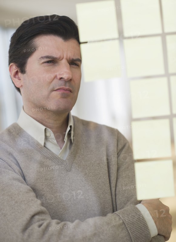 USA, New Jersey, Jersey City, Businessman observing adhesive notes on window.