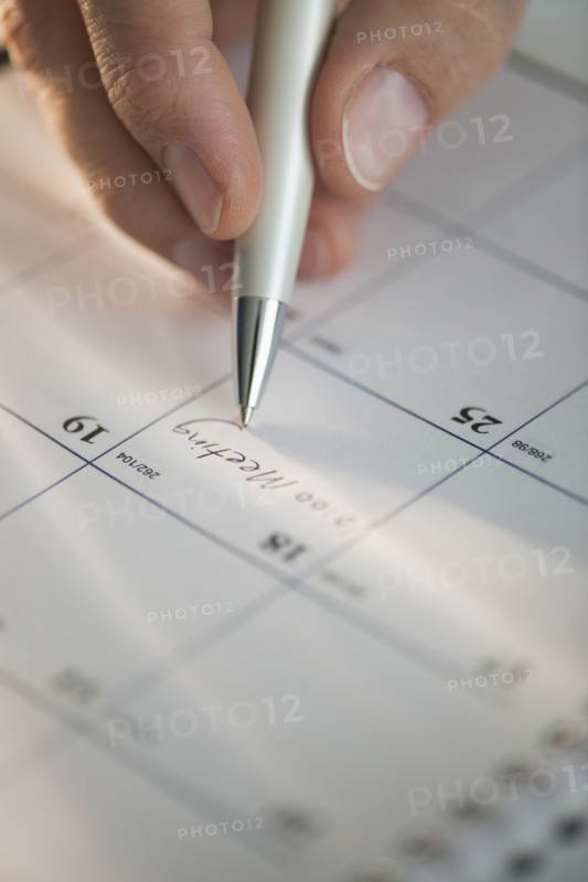USA, New Jersey, Jersey City, Man writing on calendar.