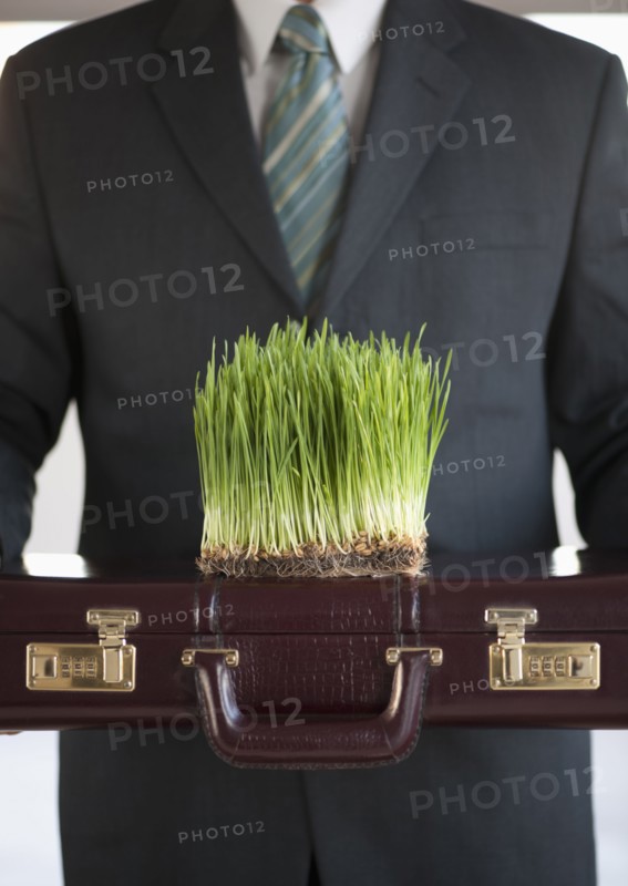 USA, New Jersey, Jersey City, Man holding growing grass in front of him.