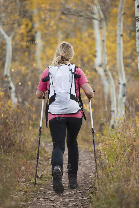 USA, Utah, young woman hiking in forest, rear view. Photo : Mike Kemp
