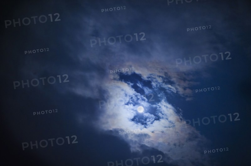 Full moon in cloudy sky at night.