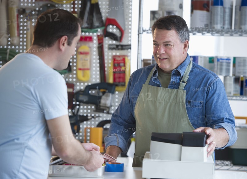 USA, New Jersey, Jersey City, Shop owner serving customer in hardware shop.