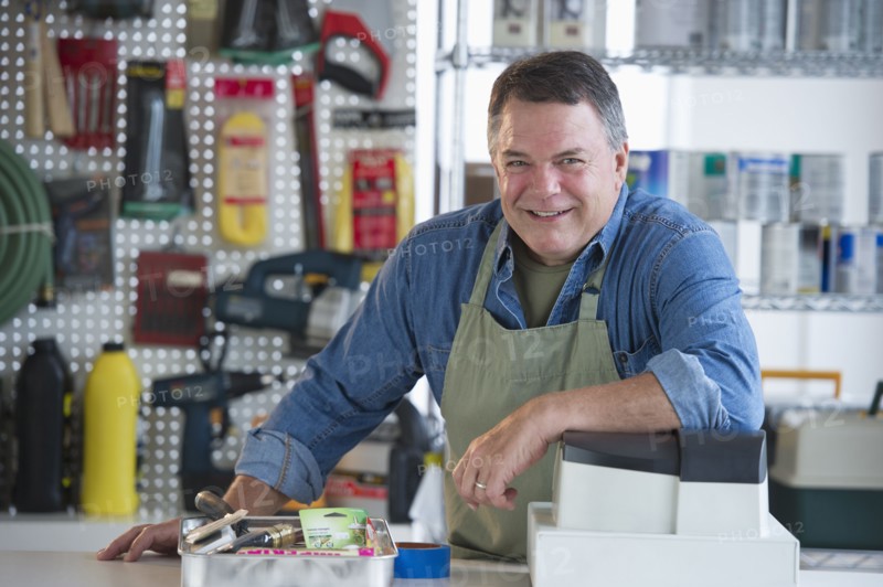 USA, New Jersey, Jersey City, Portrait of hardware shop owner at counter.