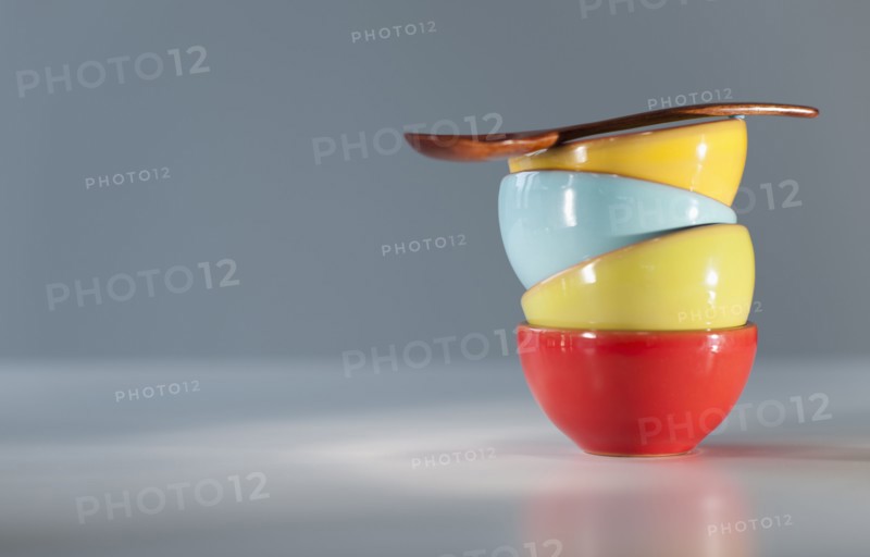 Colorful stacked bowls with spoon.