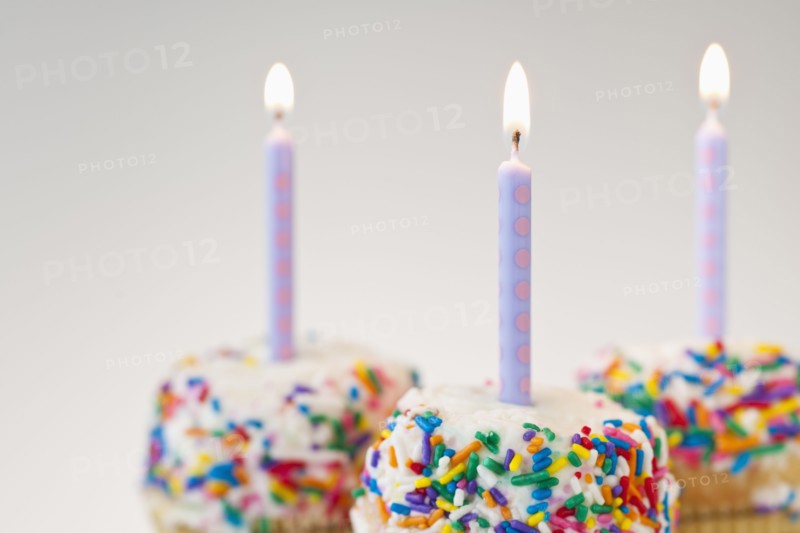 Lit candles on decorated cakes.