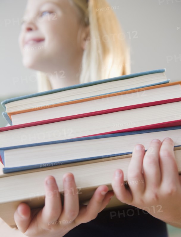 USA, New Jersey, Jersey City, Girl (8-9) carrying books. Photo : Jamie Grill Photography