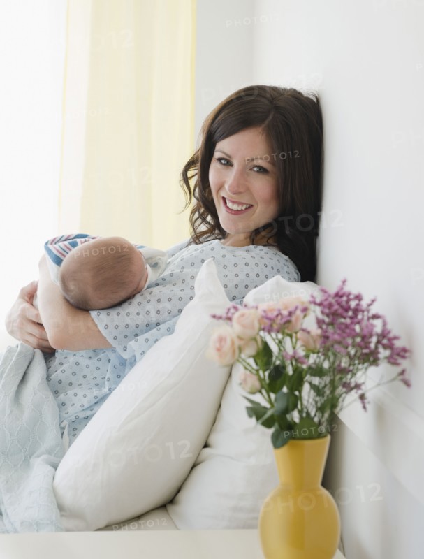 USA, New Jersey, Jersey City, Mother laying in bed with baby daughter (2-5 months). Photo : Jamie Grill Photography