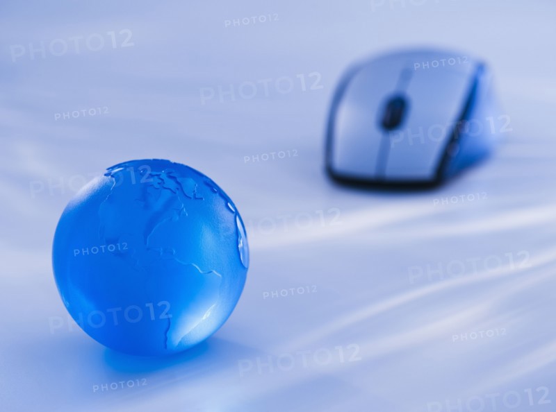 Close-up view of blue computer mouse and globe. Photo : Daniel Grill