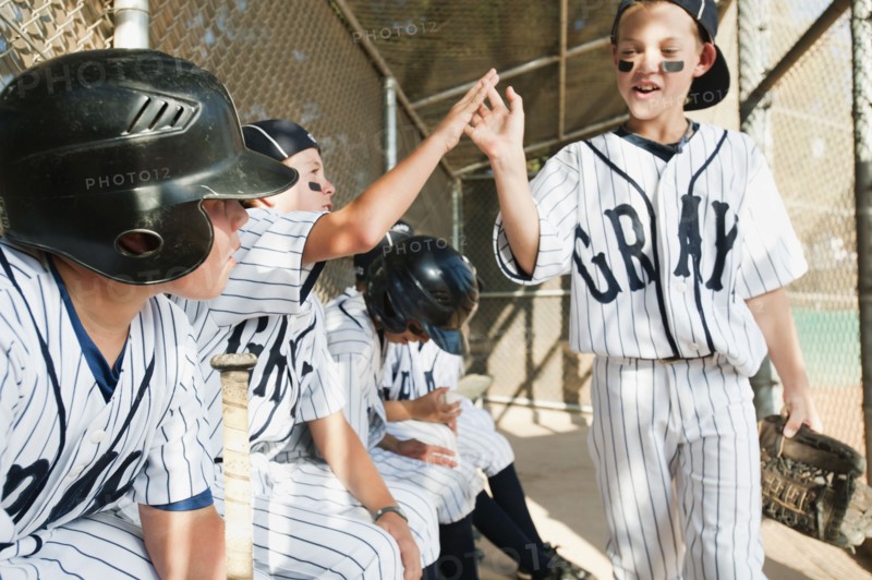 USA, California, Ladera Ranch, Boys (10-11) from little league sitting on dugout.