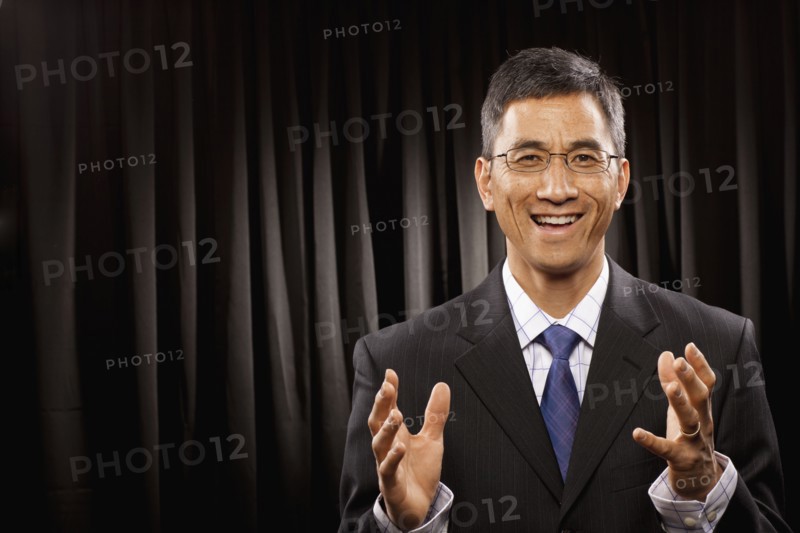 USA, Utah, Provo, Portrait of businessman having speech in front of black curtain. Photo : FBP