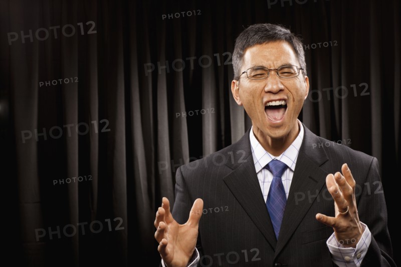 USA, Utah, Provo, Portrait of businessman having speech in front of black curtain. Photo : FBP