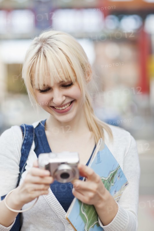 USA, Seattle, Young woman checking pictures at digital camera. Photo : Take A Pix Media