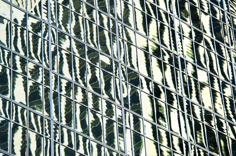 USA, New York, New York City, Reflections in windows of office block.