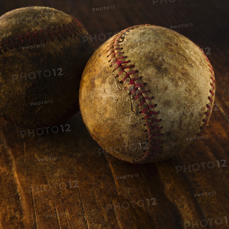 Antique baseballs on wooden floor.