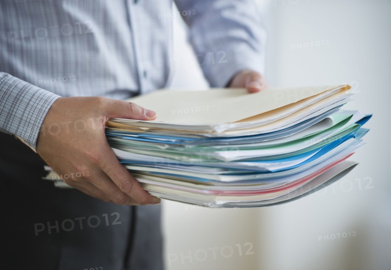 USA, New Jersey, Jersey City, Businessman carrying paperwork.