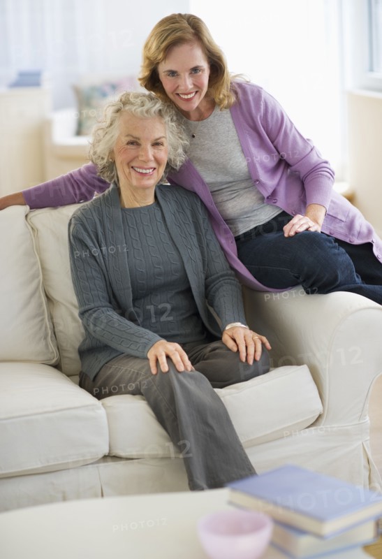 USA, New Jersey, Jersey City, Portrait of mother and daughter smiling on sofa.
