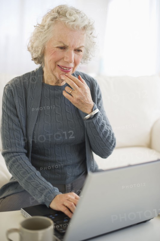 USA, New Jersey, Jersey City, Senior woman using laptop in living room.