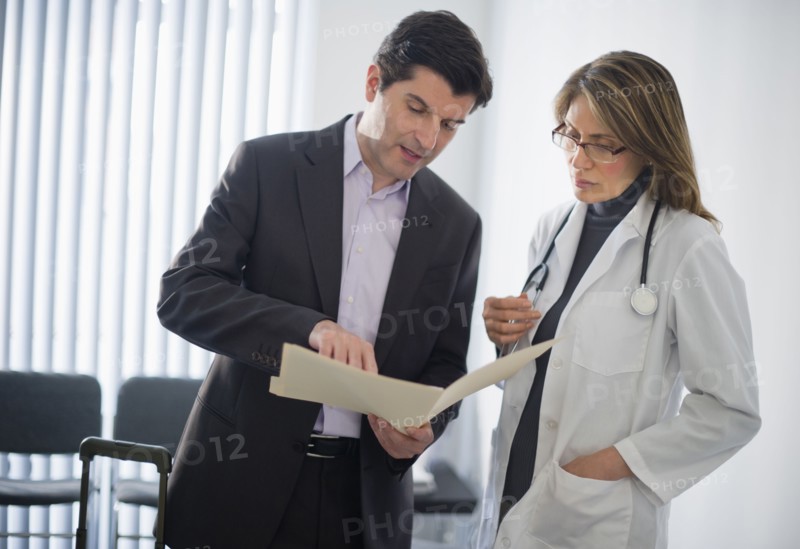USA, New Jersey, Jersey City, Medical sales representative talking with female doctor in office.