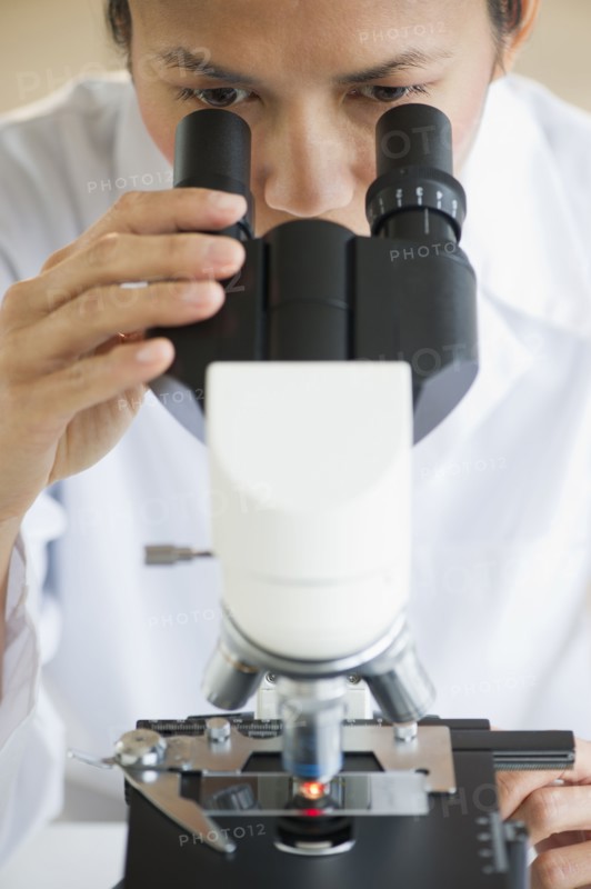 USA, New Jersey, Jersey City, Female scientist using microscope.