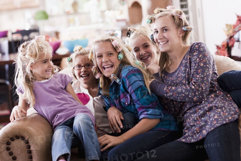 USA, Utah, family portrait of sisters (6-7, 8-9, 12-13, 14-15, 16-17) on sofa having fun. Photo : Tim Pannell