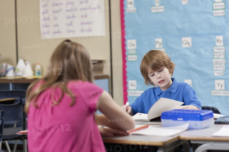 Girl (10-11) and boy (6-7) reading in classroom. Photo : Dan Bannister
