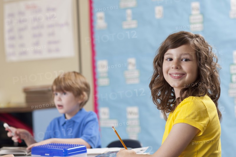 Girl (10-11) and boy (6-7) in classroom. Photo : Dan Bannister