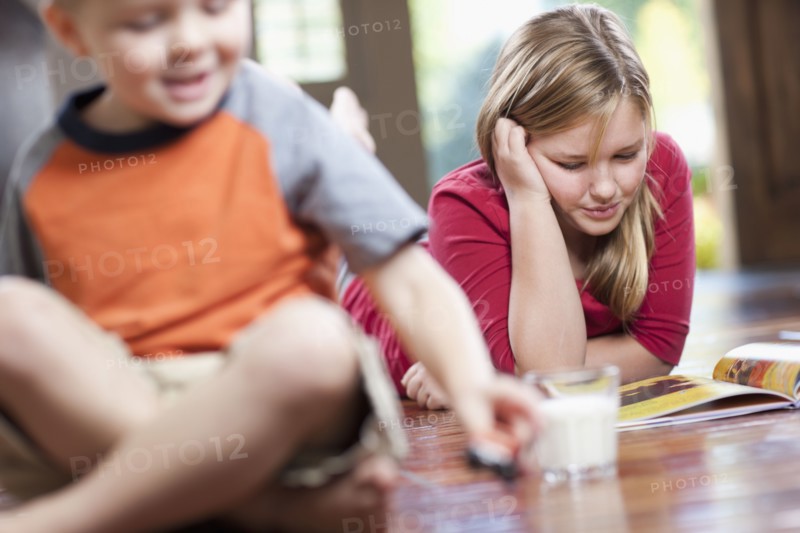 USA, Utah, Children (4-11) relaxing in home, girl reading book. Photo : Tim Pannell