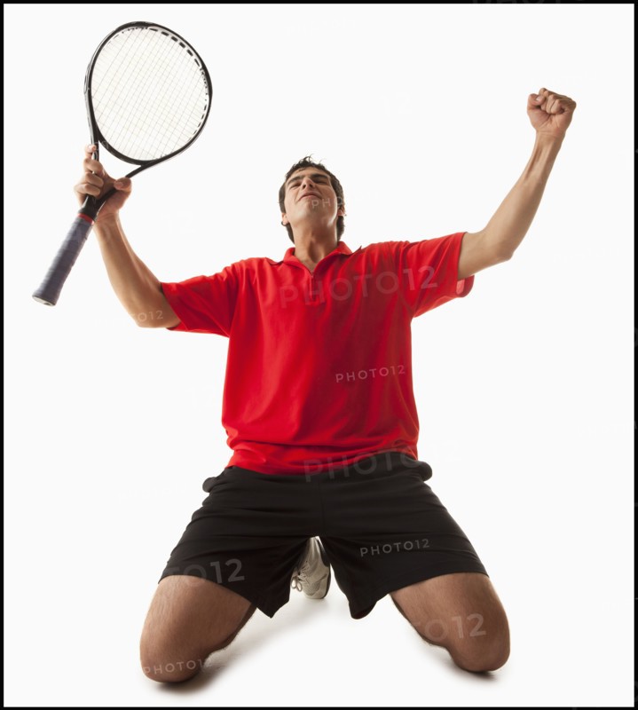 Young man playing tennis winning. Photo : Mike Kemp
