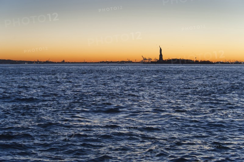 USA, New York City, Staten Island, Harbor and silhouette of Statue of Liberty in background.