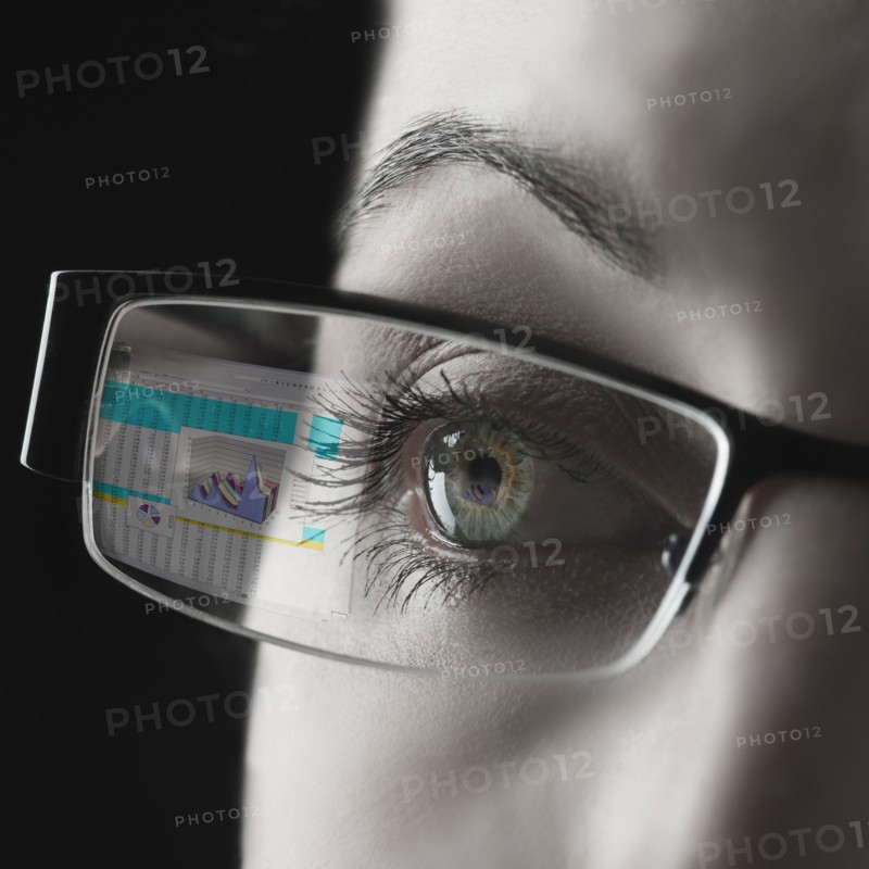 Reflection of graph in businesswoman's glasses.