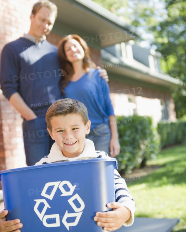 USA, New York, Flanders, Boy (8-9) holding bucket with recycling symbol, parents in background. Photo : Jamie Grill Photography