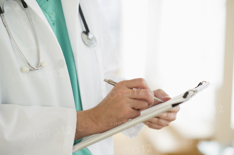 USA, New Jersey, Jersey City, Male doctor writing medical report.