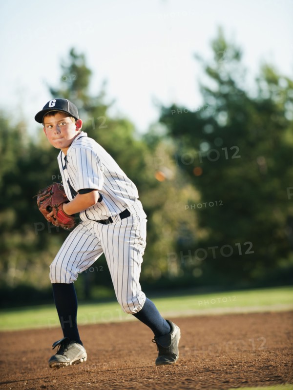Boy (10-11) playing baseball.