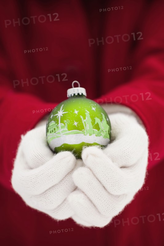 Young woman holding Christmas bauble. Photo : Mike Kemp