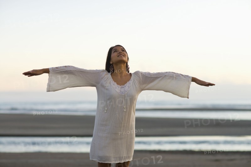 USA, California, Stinson Beach, Young woman with arms up on beach. Photo : Noah Clayton
