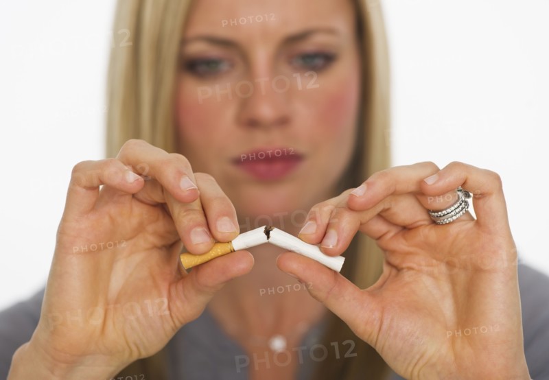 Young woman breaking cigarette. Photo : Daniel Grill