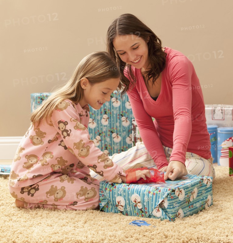 Two sisters (6-7, 18-19) wrapping Christmas presents. Photo : Mike Kemp