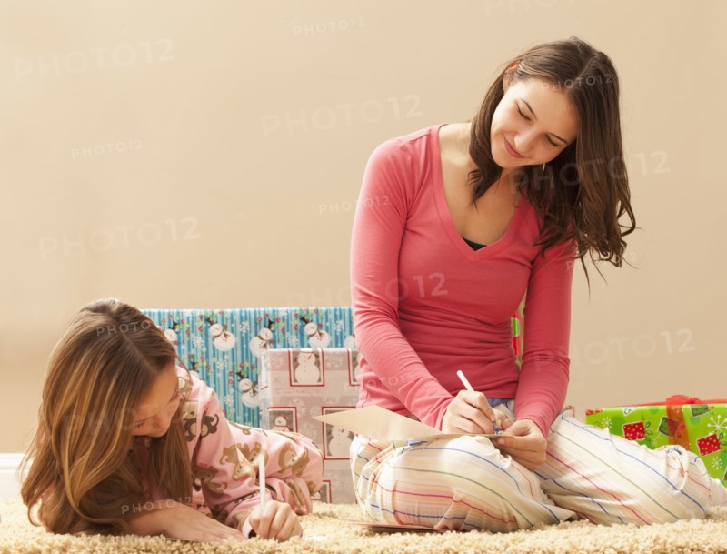 Two sisters (6-7, 18-19) wrapping Christmas presents. Photo : Mike Kemp