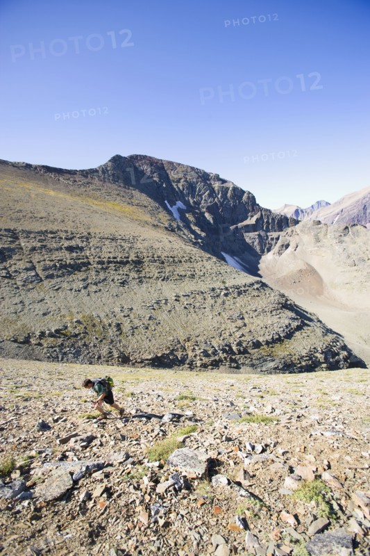 USA, Montana, Glacier National Park, Mid adult man hiking . Photo : Noah Clayton