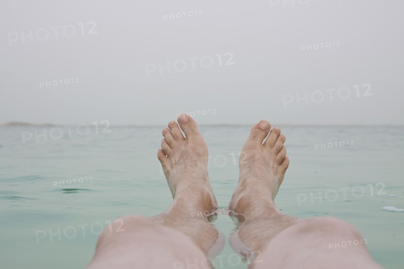 Israel, Dead Sea, mature men's legs in sea. Photo : Johannes Kroemer