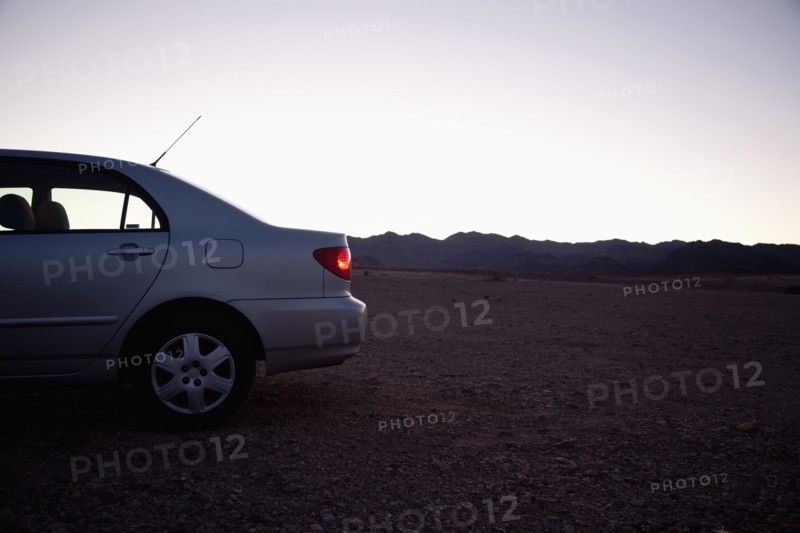 USA, Nevada, car on desert road at dusk. Photo : Johannes Kroemer
