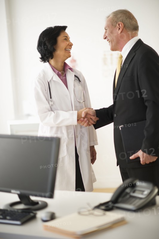 Female doctor shaking hands with hospital executive.