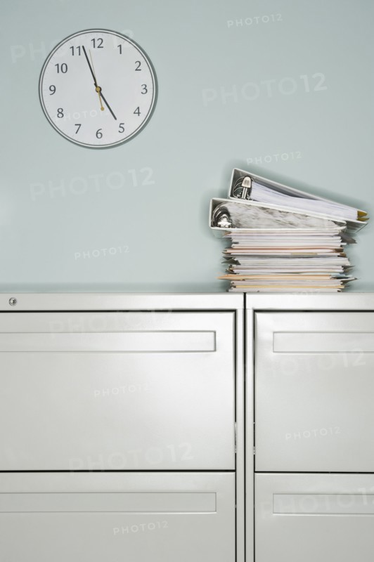 Stack of documents on filing cabinet.