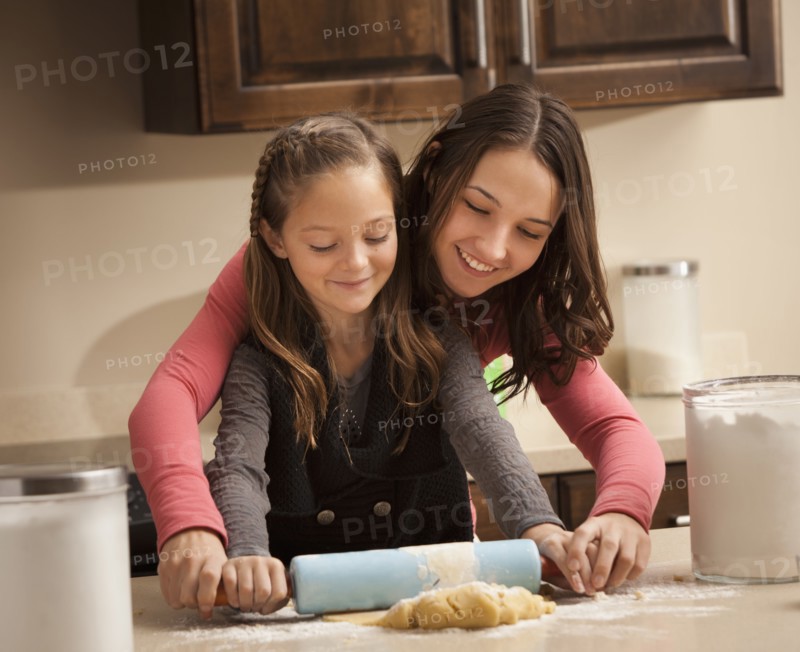 Two sisters (6-7, 18-19) rolling dough. Photo : Mike Kemp
