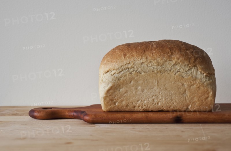 Close up of loaf of bread on cutting board.
