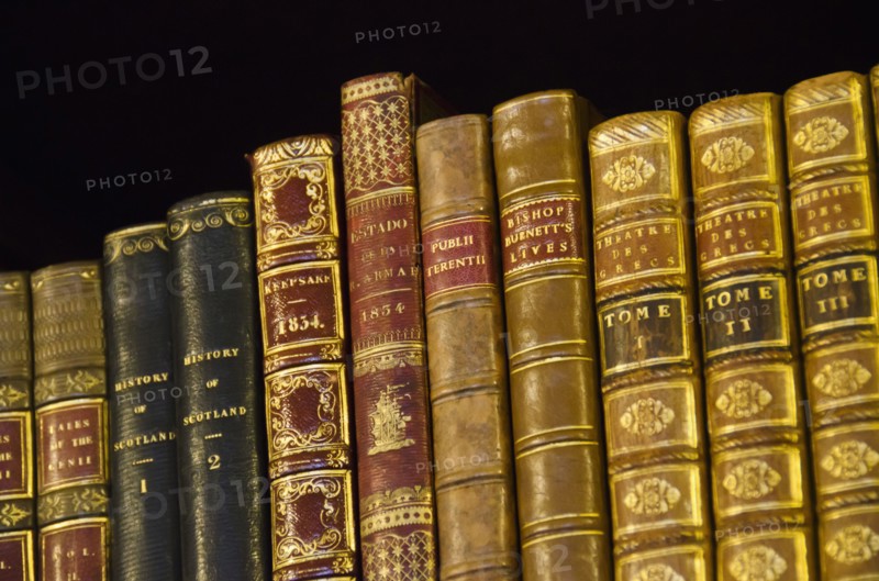 Close up of antique books on shelves.