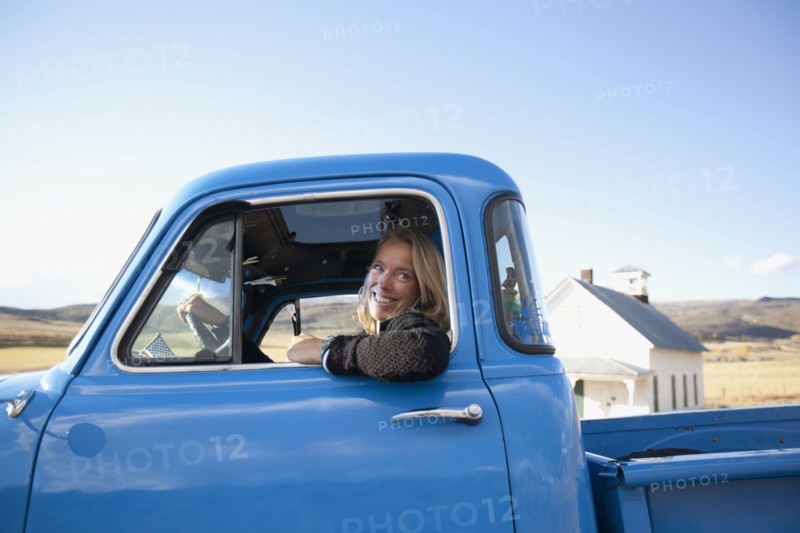 USA, Colorado, Carbondale, Cowgirl driving old fashioned pickup truck. Photo : Noah Clayton